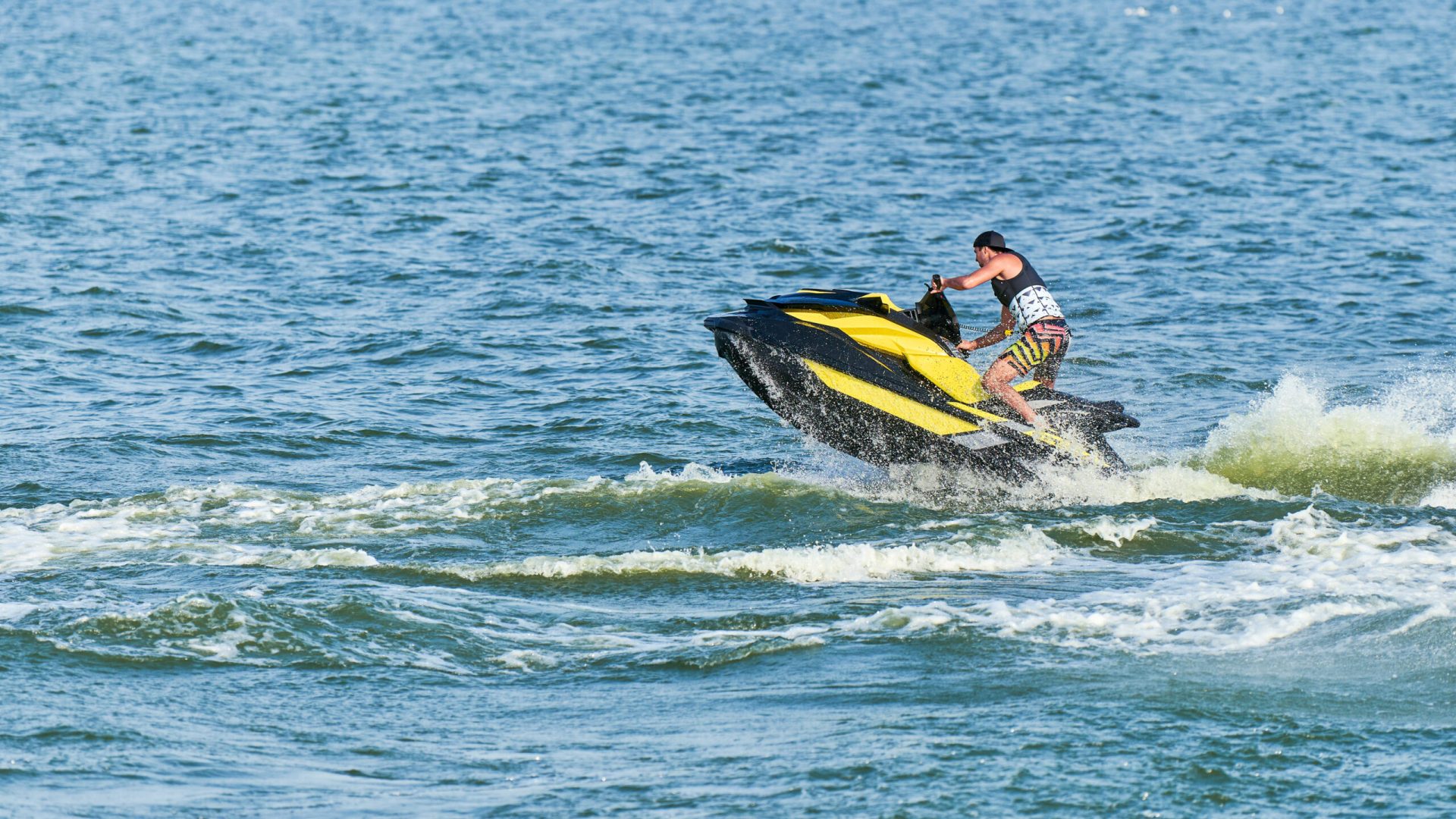 Man on water scooter. Summer vacation on personal watercraft in tropical sea. Young guy sea riding hobby. PWC sport activity
